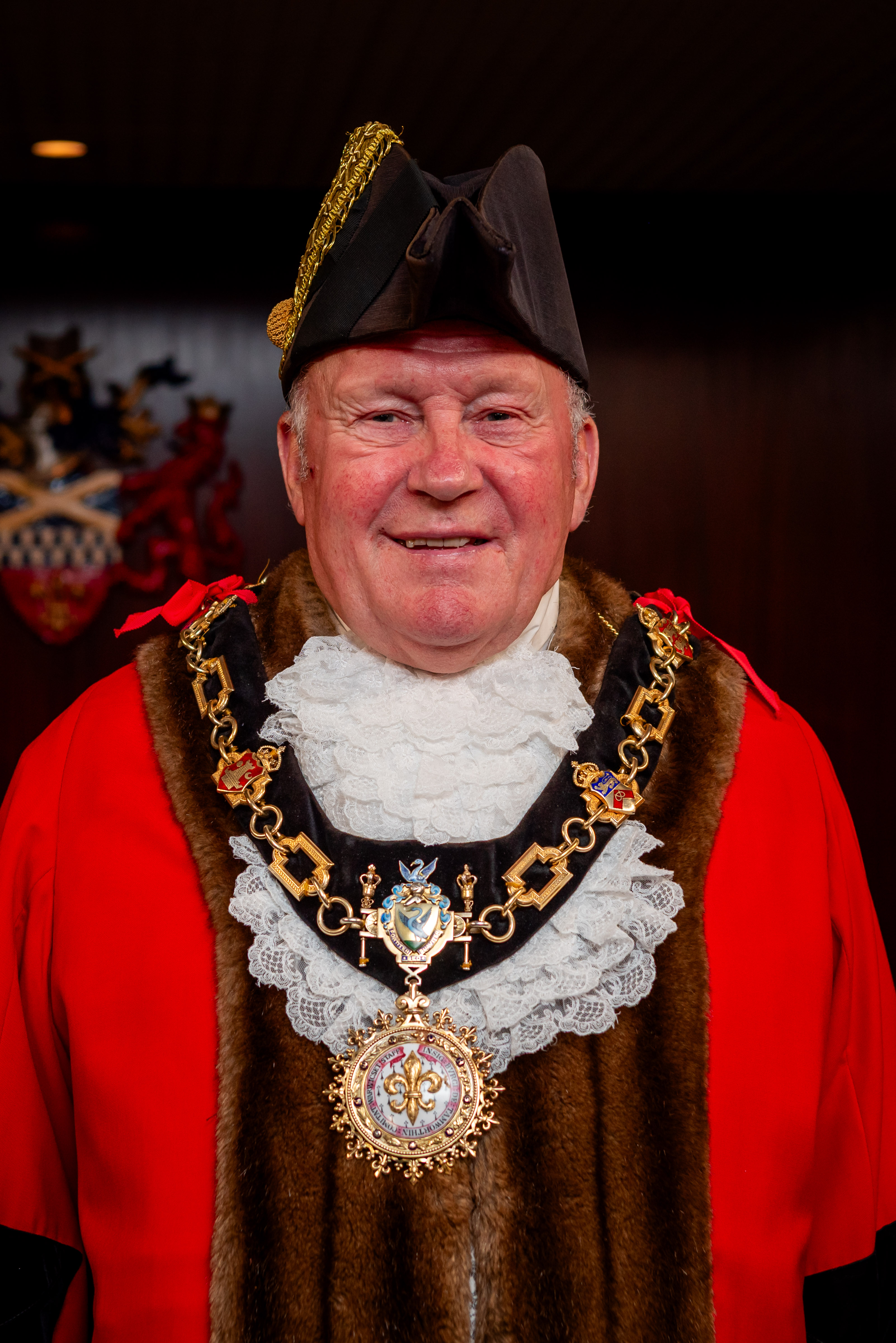 male wearing mayor red robes and hat, gold chains 