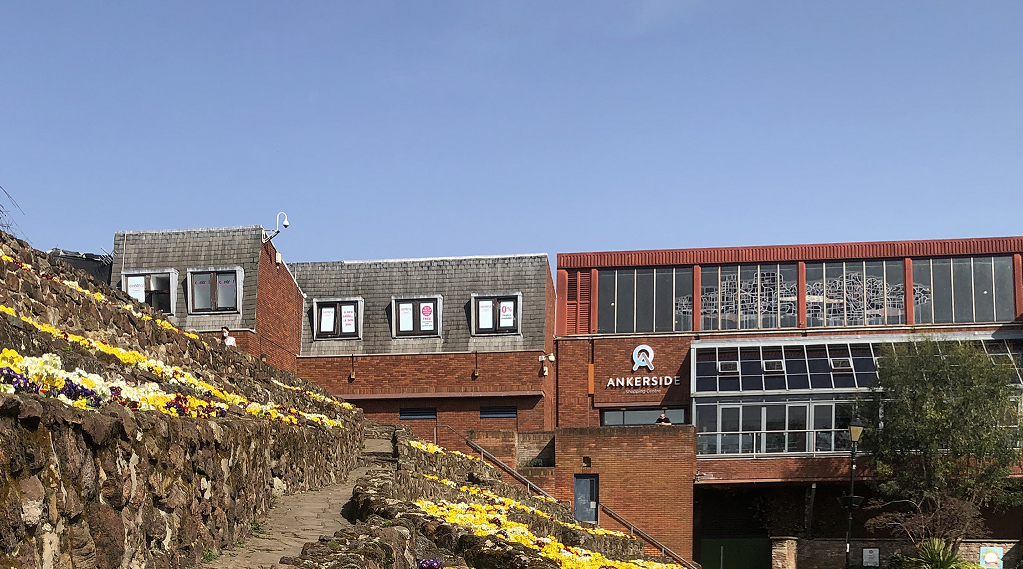 Ankerside shopping centre building with blue sky and flower beds