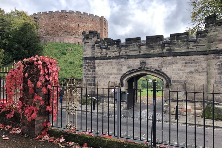 photo of a old turret building and archway with a castle in the background