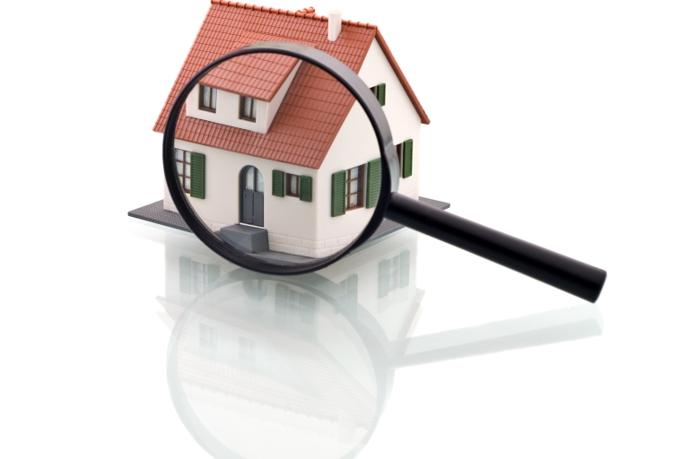 A magnifying glass over a graphic image of a house