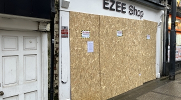Shop boarded with closure notices on