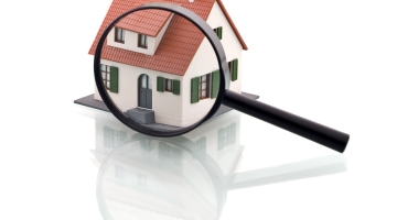 A magnifying glass over a graphic image of a house